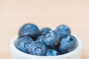 Blueberry in a bowl on wooden table background