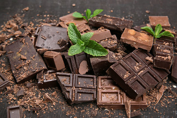 Chocolate pieces with mint leaves on black background