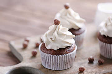 Tasty cupcakes on cutting board, closeup