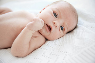 Newborn baby girl, 7 days old, lying on soft blanket