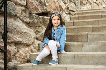 Little girl wearing stylish clothes outdoors. Fashion kid concept