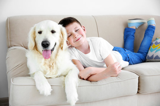 Small Boy And Cute Dog On Couch