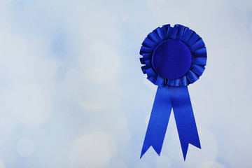 Blue award prize ribbon on blurred background