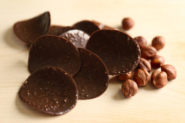 Chocolate chips and hazelnuts on wooden background