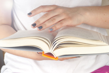 Young girl reading an  open book  old book. Books and reading are essential for self improvement, gaining knowledge and success in our careers, business and personal lives.