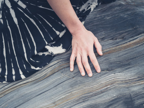 Hand of woman touching rock surface