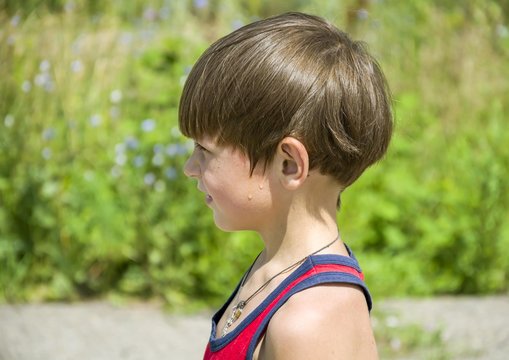 Мальчик с капельками пота на щеке в жаркий день