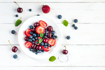 Fototapeta na wymiar fruit salad on white wooden background, top view, flat lay