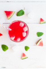 watermelon juice and watermelons slices on wooden white background, top view, flat lay
