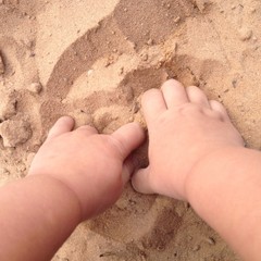 детские ручки копаются в песке