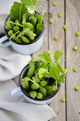 Fresh green peas on rustic wooden background, top view