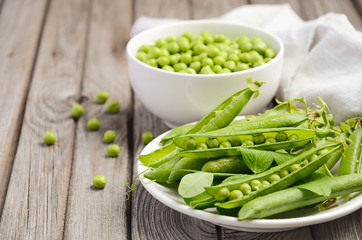 Fresh green peas on rustic wooden background, selective focus, copy space