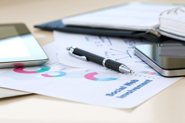 Mobile Business Background with color printed professional Chart and hand written Scheme on piece of Paper and digital Gadgets screens on Vintage sepia toned Desk