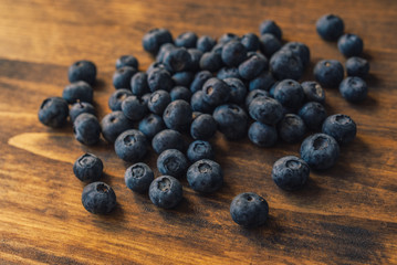 Tasty ripe blueberry pile on wooden table