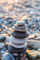 Pebbles pyramid on beach in sunset time