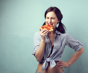 Beautiful girl eating a slide of pizza