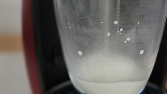 Hot milk pouring into the glass, closeup shot in HD