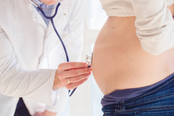 Healthcare, medical: Doctor examining a pregnant woman. 