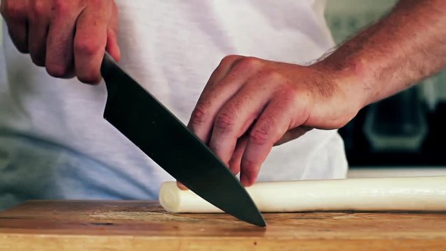 Professional chef slicing green onion