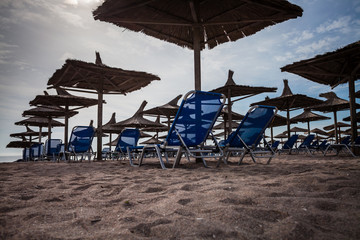 Color picture of straw beach umbrella and beach chairs