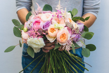 Florist at work: woman making fashion modern bouquet of different flowers