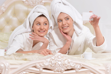 women in  bathrobes doing selfie