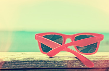 Red sunglasses on blue sea  and sky background