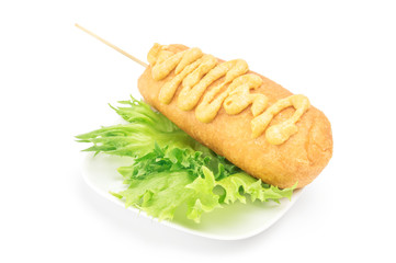 Corn dog with mustard on the plate
