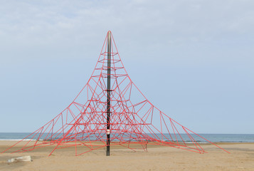 Fototapeta na wymiar rope pyramid for children to play on a beach in the Mediterranea