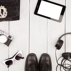 shoes, jeans, tablet pc, camera, headphones, sunglasses on wood