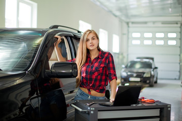 Fototapeta na wymiar a young woman in a garage. Auto diagnostic service