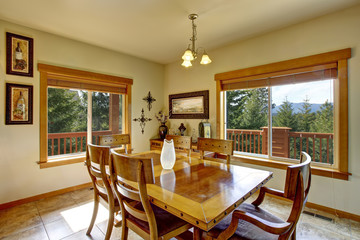 View of wooden table set in the dining room with marble tile floor.