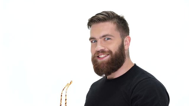 Young bearded tricky crazy man with eyeglasses holding a book 