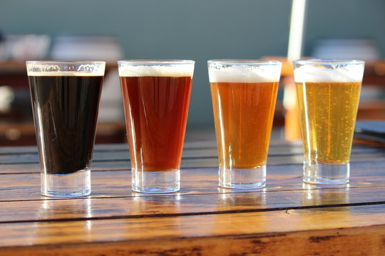 A selection of four craft beers during a tasting session on a wooden table