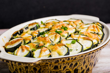 Casserole with zucchini, cheese and fresh basil in baking dish