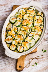 Casserole with zucchini, cheese and fresh basil in baking dish