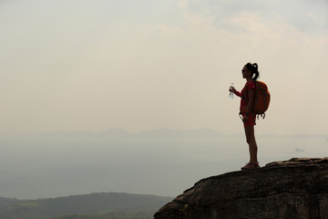 woman hiker enjoy the view at sunset mountain peak cliff