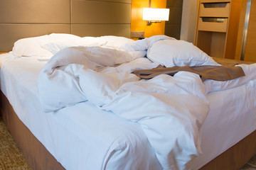 Unmade bed in hotel bedroom