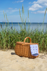 Picnic basket with blue white napkin on the beach