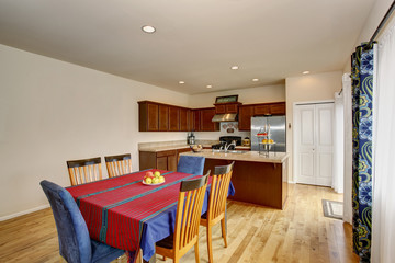 Bright kitchen and dining room interior with white walls and hardwood floor.