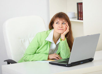 Girl dreams working with laptop at office