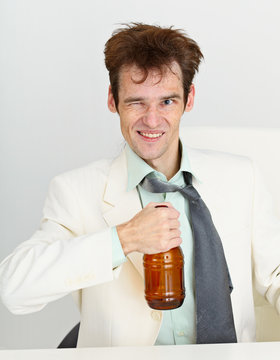 Cheerful guy in a white jacket with bottle of beer
