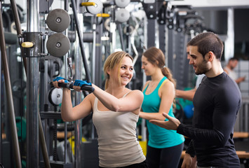 Fototapeta na wymiar Adults having strength training under coach control in gym