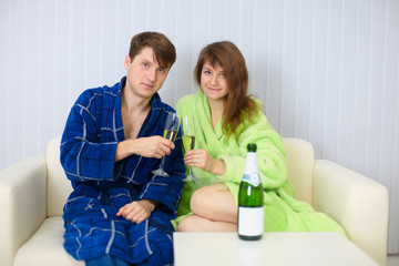 Fototapeta premium Husband and wife in a holiday on sofa with champagne wine