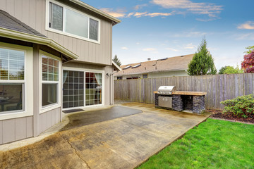 Cozy patio area with concrete floor and barbecue.