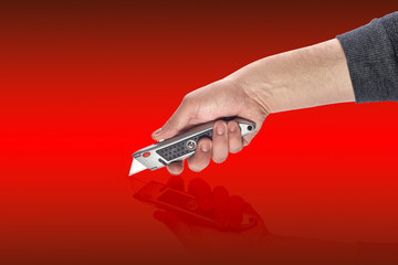 man's hand holding a knife stationery