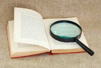 Still life of magnifying glass and old book - obrazy, fototapety, plakaty