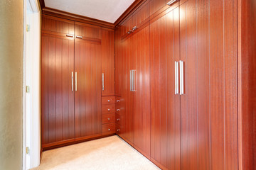 Luxury wardrobe room with brown modern built-in cabinets