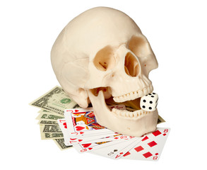 Human skull, playing cards and money