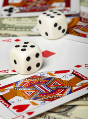 Dice against of playing cards and money